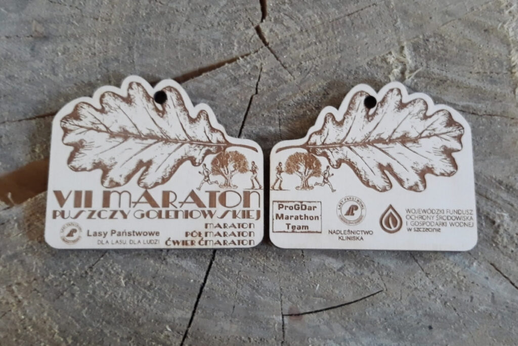 Medal Puszcza Goleniowska, drewniane trofeum biegowe, eko medal leśny, pamiątka z maratonu w lesie, grawerowany medal brzozowy, nagrody dla biegaczy trailowych.