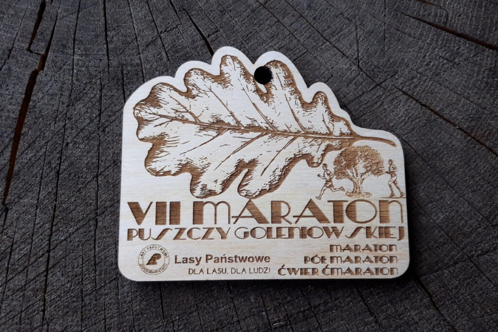 Medal Puszcza Goleniowska, drewniane trofeum biegowe, eko medal leśny, pamiątka z maratonu w lesie, grawerowany medal brzozowy, nagrody dla biegaczy trailowych.