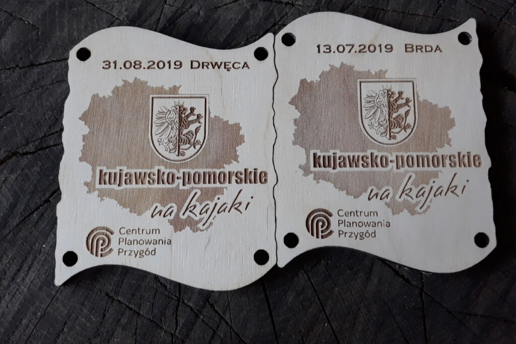 Zestaw dwóch drewnianych medali z grawerem mapy, które po złączeniu tworzą dopasowaną tabliczkę.