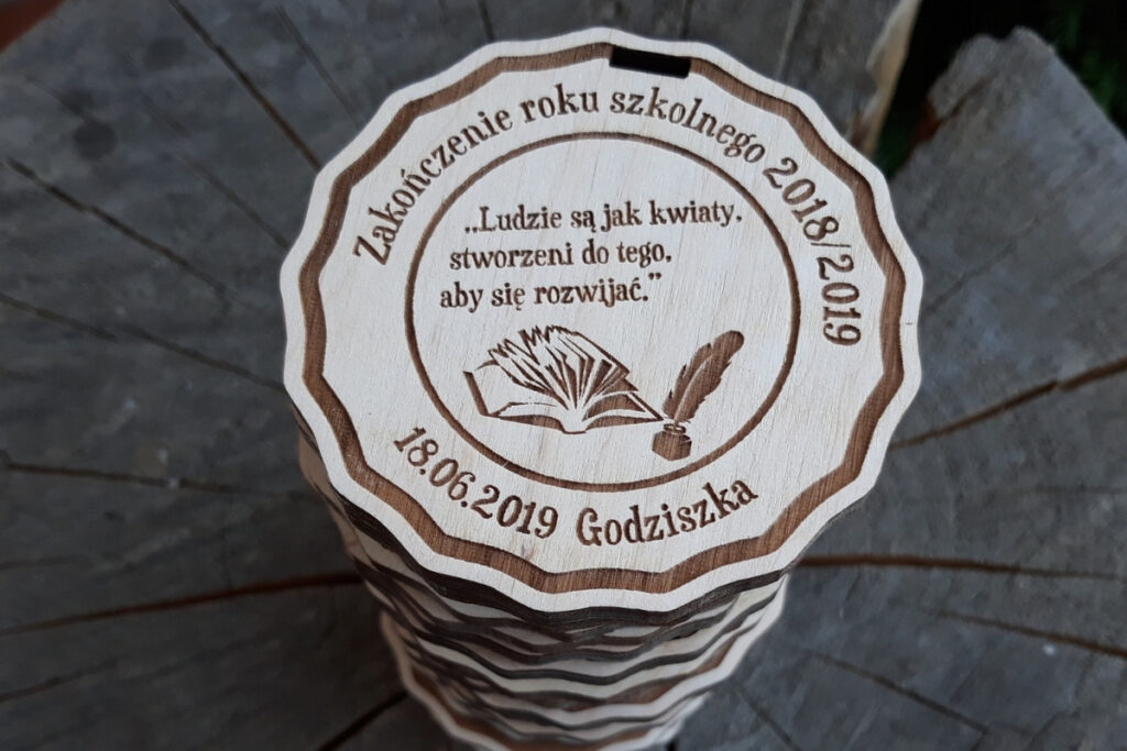 Okrągły drewniany medal z grawerem sowy w birecie, napisem Super Uczeń oraz miejscem na rok szkolny i nazwę szkoły.