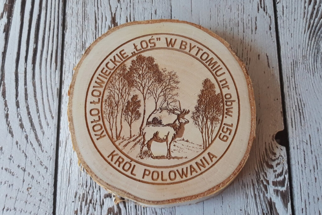 Medal z naturalnego plastra brzozy z korą, grawerem dumnego jelenia byka, napisem Król Polowania.