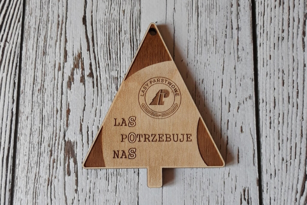 
Trójkątny drewniany medal "SOS - Las potrzebuje nas", wykonany z czystej brzozy bez osmaleń, zawieszony na ekologicznym sznurku.