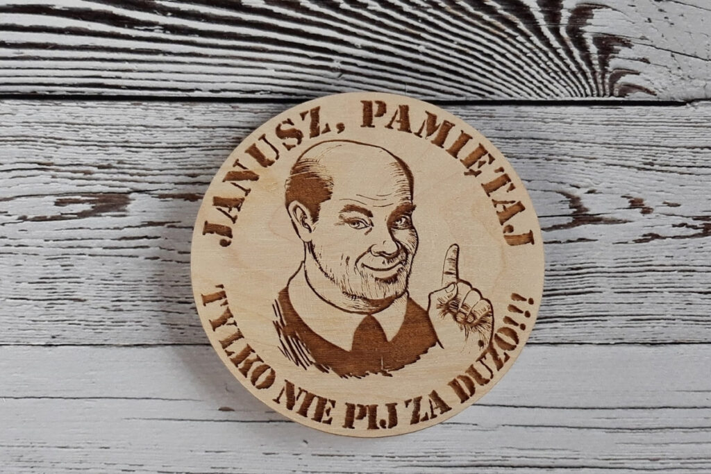 Personalizowana drewniana podstawka pod kufel lub szklankę z zabawnym grawerem „Janusz tylko nie pij za dużo”, wykonana z jasnej, czystej brzozy bez osmaleń.