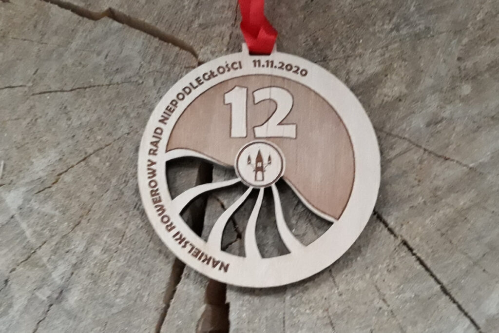 Okrągły drewniany medal na Rowerowy Rajd Niepodległości.