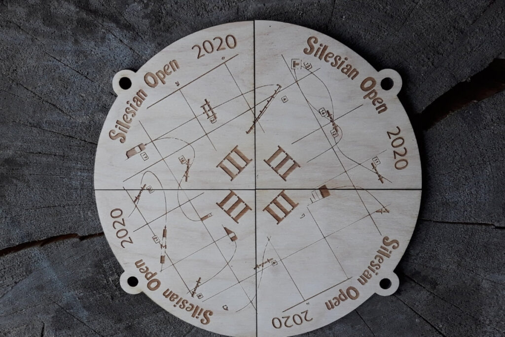Zestaw czterech drewnianych medali na turniej Silesian Open, które po złożeniu tworzą pełną okrągłą tabliczkę z motywem kuli ziemskiej, mapą i logotypem wydarzenia, wykonany z czystej płyty brzozy bez osmaleń.
