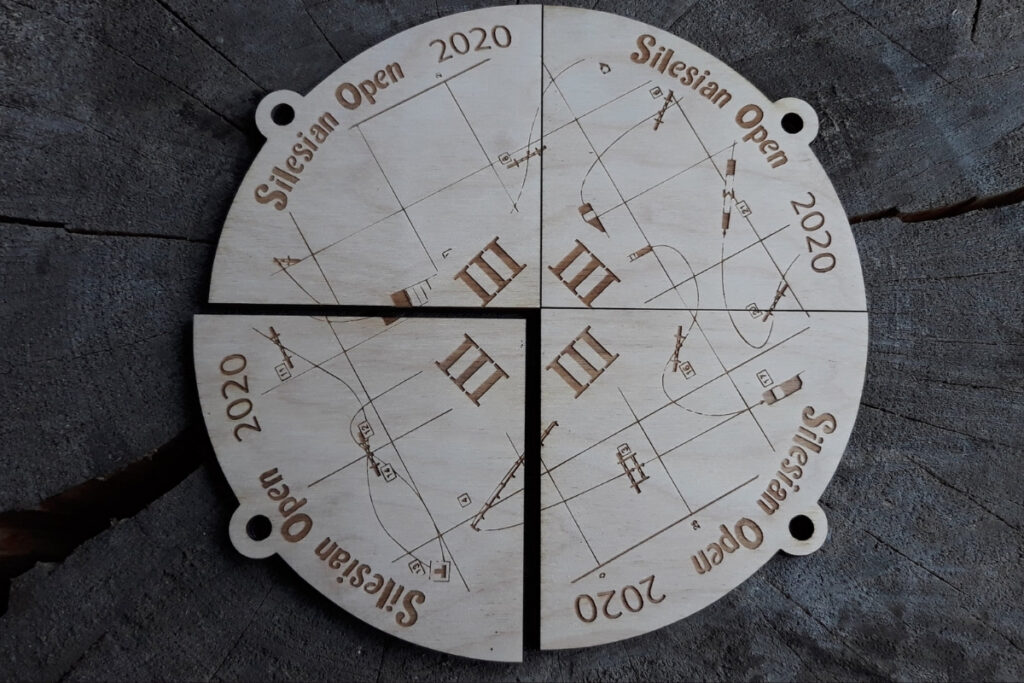 Zestaw czterech drewnianych medali na turniej Silesian Open, które po złożeniu tworzą pełną okrągłą tabliczkę z motywem kuli ziemskiej, mapą i logotypem wydarzenia, wykonany z czystej płyty brzozy bez osmaleń.