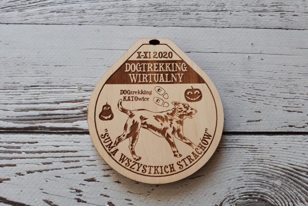 Drewniany medal na zawody Dogtrekking, z grawerem sylwetki psa oraz napisem „Dogtrekking”, wykonany z jasnej brzozy bez śladów dymu.