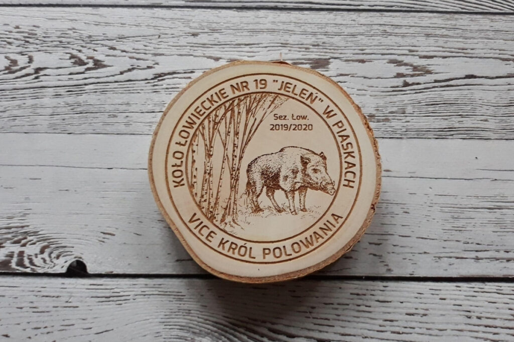 Drewniany medal na naturalnym plastrze brzozy z korą dla Vice Króla Polowania, z grawerem dzika i drzewami, napisem „Vice Król Polowania” oraz nazwą Koła Łowieckiego, czysta powierzchnia bez osmaleń.