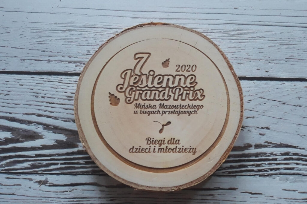 Drewniany medal na naturalnym plastrze brzozy z korą na „7. Jesienne Grand Prix”, z numerem edycji oraz nazwą zawodów, czysta powierzchnia bez śladów dymu.