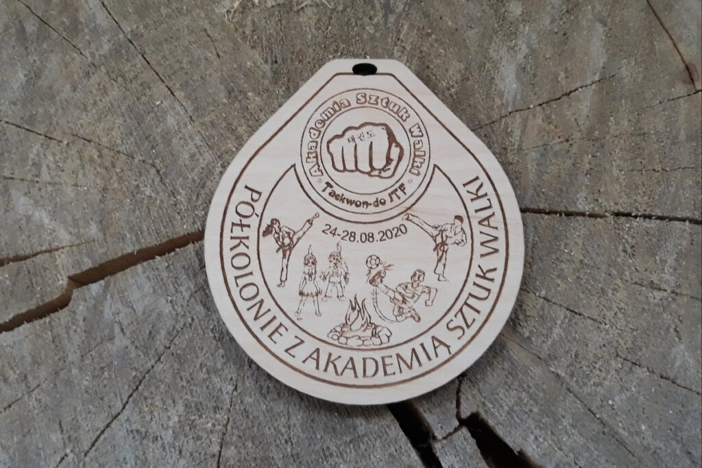 Drewniany medal pamiątkowy na półkolonie, z grawerem dzieci podczas różnych dyscyplin sportowych.