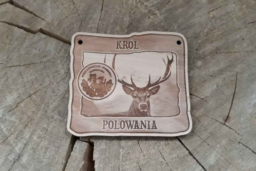 Prostokątny drewniany medal dla Króla Polowania z grawerem dumnego jelenia byka, napisem „Król Polowania” oraz miejscem na logotyp Koła Łowieckiego, wykonany z czystej brzozy bez osmaleń.