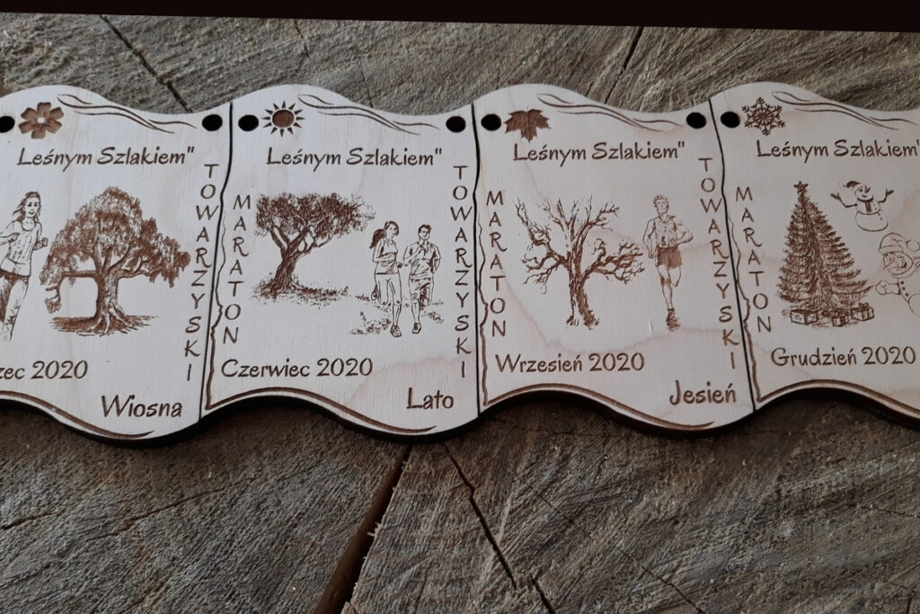 Zestaw czterech drewnianych medali modułowych „4 Pory Roku”, które po dopasowaniu tworzą kompletną prostokątną tabliczkę, z grawerem symboli zimy, wiosny, lata i jesieni, wykonany z czystej brzozy bez śladów osmaleń. Medale można połączyć w pionie i w poziomie.