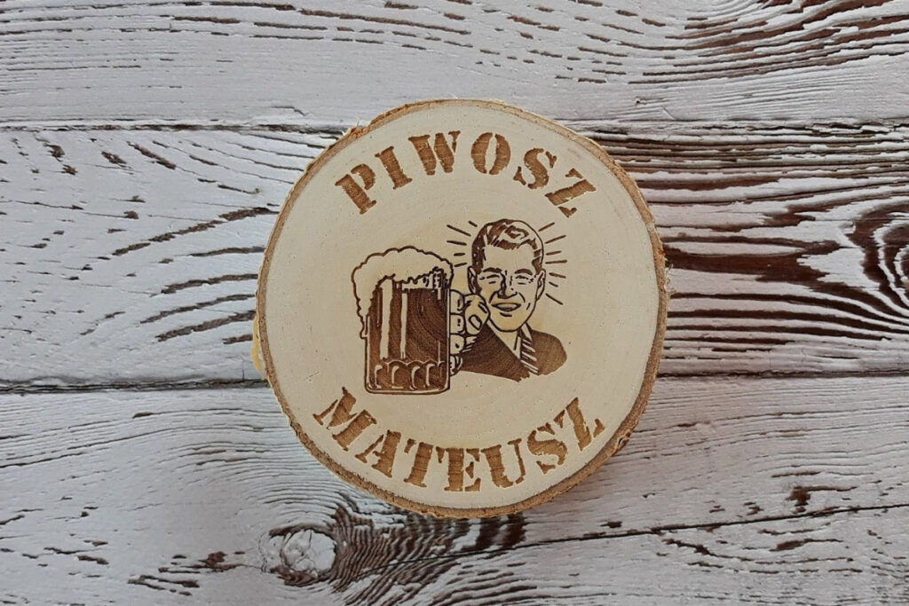 Personalizowana podkładka pod piwo na naturalnym plastrze brzozy z korą, z grawerem „Piwosz Mateusz”, motywem kufla z pianą, wykonana z czystego drewna bez osmaleń.