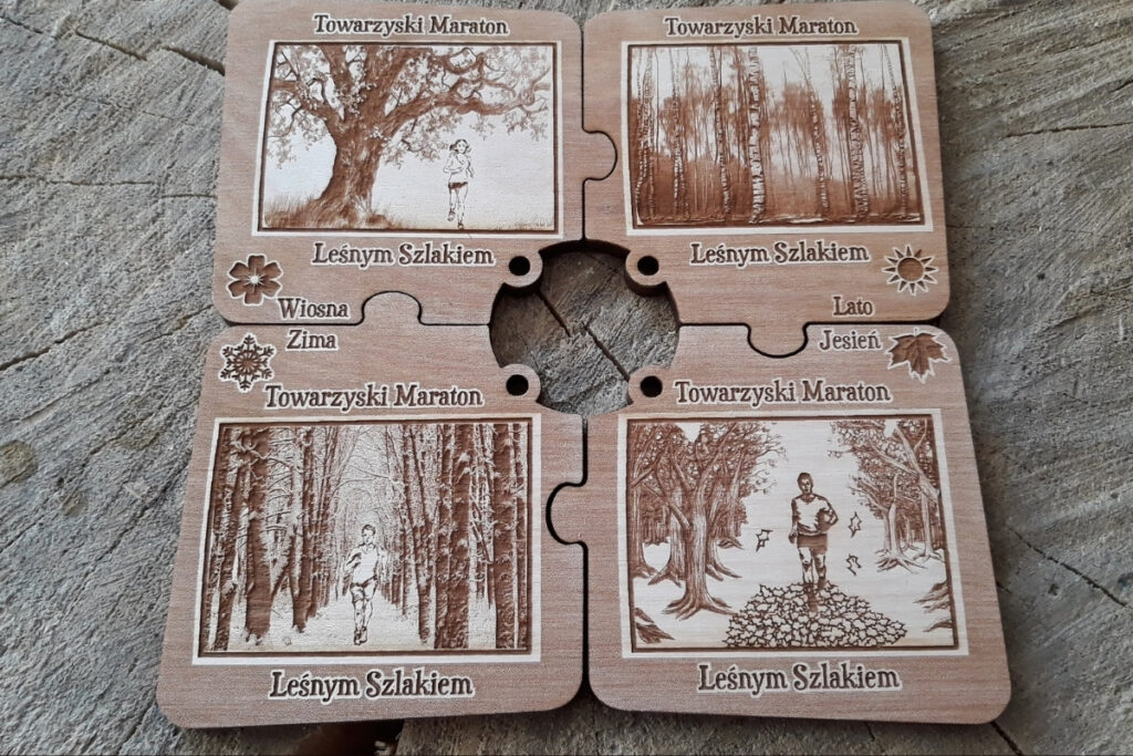 Zestaw czterech drewnianych medali w kształcie puzzli, które po złożeniu tworzą spójną kwadratową tabliczkę z motywami czterech pór roku: wiosny, lata, jesieni i zimy, wykonany z jasnej brzozy bez osmaleń.