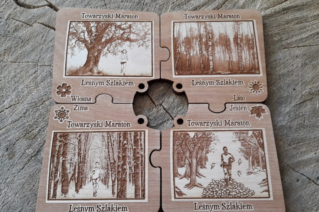 Zestaw czterech drewnianych medali w kształcie puzzli, które po złożeniu tworzą spójną kwadratową tabliczkę z motywami czterech pór roku: wiosny, lata, jesieni i zimy, wykonany z jasnej brzozy bez osmaleń.