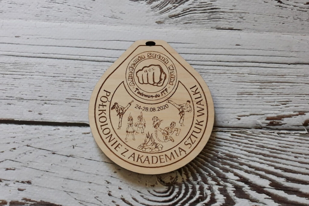 Drewniany medal pamiątkowy na półkolonie, z grawerem dzieci podczas różnych dyscyplin sportowych.