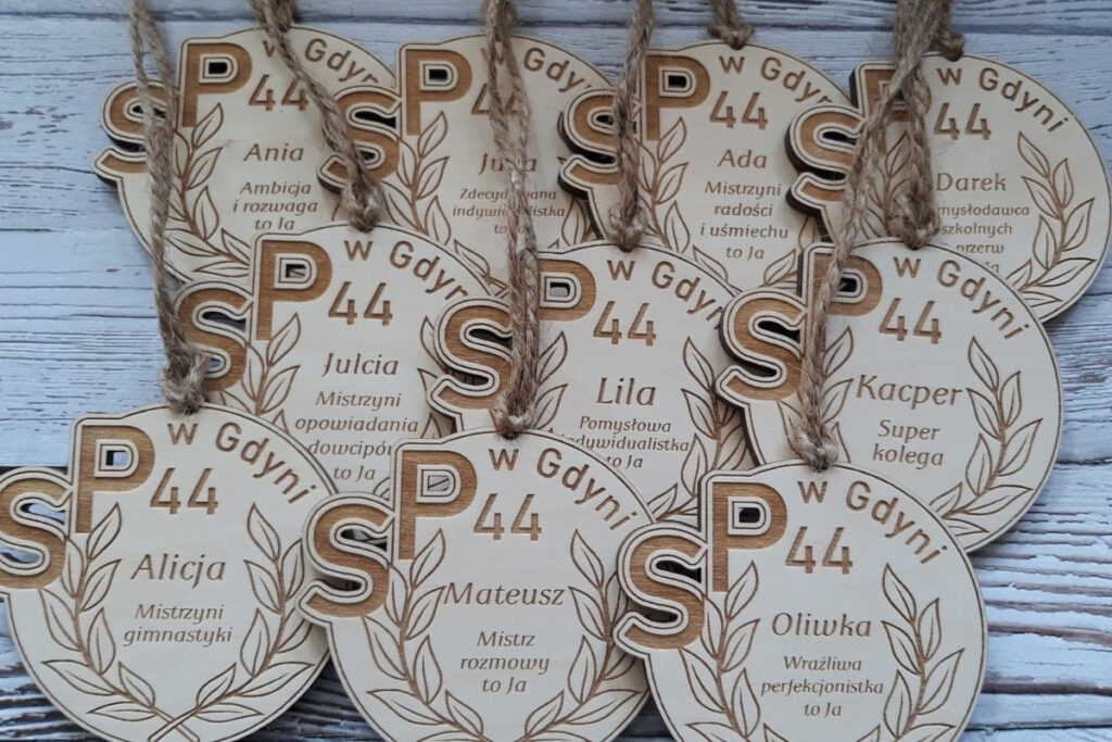 Okrągły drewniany medal na zakończenie roku szkolnego z personalizowanym grawerem imienia dziecka, krótkim tekstem o dziecku, wykonany z czystej brzozy bez osmaleń.