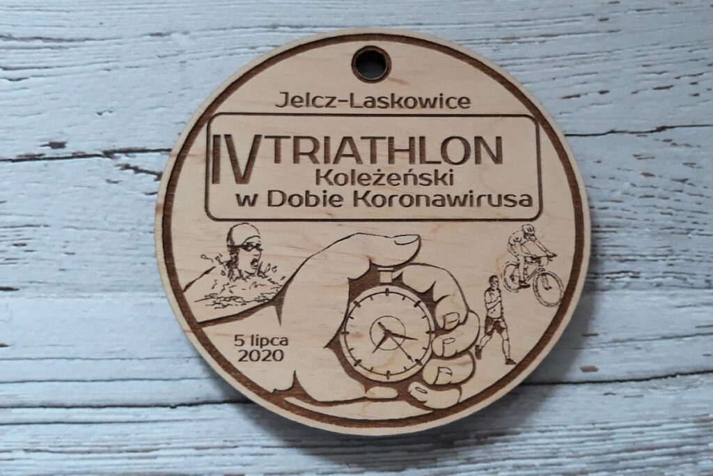 Okrągły drewniany medal na Triathlon Koleżeński z grawerem trzech dyscyplin: pływania, jazdy na rowerze i biegania.